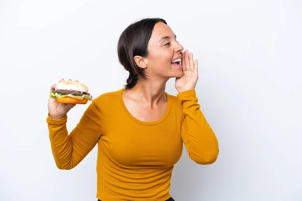 Young Hispanic Woman Holding Burger Isolated White Background Shouting Mouth — Stock Photo, Image