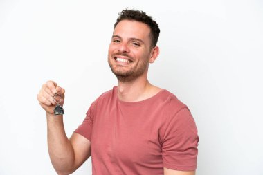 Beyaz arka planda izole edilmiş ev anahtarlarını elinde tutan beyaz bir adam.