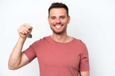 Beyaz arka planda izole edilmiş ev anahtarlarını elinde tutan beyaz bir adam.