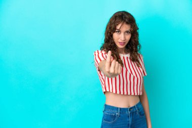 Mavi arka planda, kıvırcık saçlı genç bir kadın geliyor.