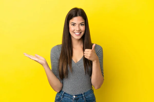 Young Brazilian Woman Isolated Yellow Background Holding Copyspace Imaginary Palm — Foto de Stock