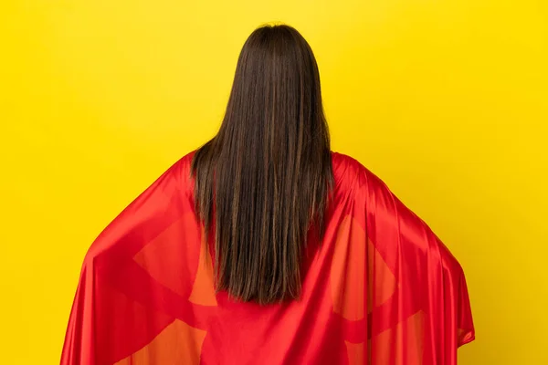 バックポジションで黄色の背景に隔離されたスーパーヒーローブラジル人女性 — ストック写真