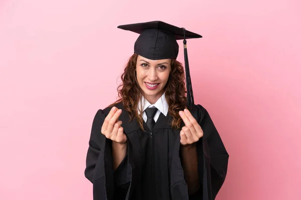 Νεαρή Απόφοιτος Πανεπιστημίου Γυναίκα Απομονωμένη Ροζ Φόντο Κάνοντας Χειρονομία Χρήματα — Φωτογραφία Αρχείου