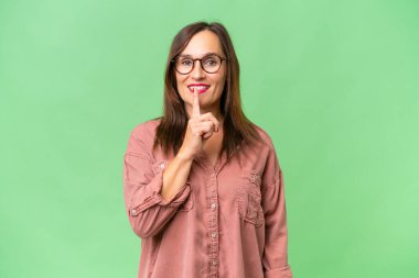 Orta yaşlı beyaz kadın, izole edilmiş geçmişinde parmağını ağzına sokan sessiz bir jest işareti var.