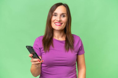 Orta yaşlı beyaz bir kadın cep telefonu kullanıyor.