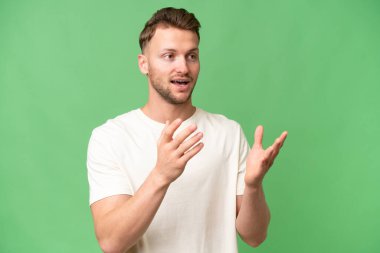 Sarışın, beyaz, yalıtılmış bir geçmişi olan, sürpriz bir yüz ifadesi olan genç bir adam.