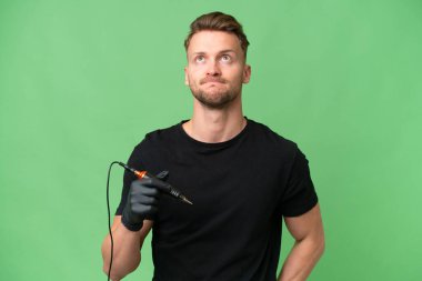 Dövme sanatçısı beyaz bir adam izole edilmiş arka planda ve araştırıyor