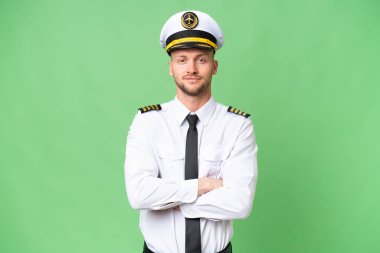 Uçak pilotu izole edilmiş arka planda kollarını ön cephede çapraz tutuyor.