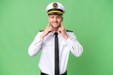 Uçak pilotu izole edilmiş arka planda mutlu ve hoş bir ifadeyle gülümsüyor.