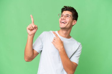 İzole edilmiş geçmişi olan beyaz, yakışıklı genç bir adam işaret parmağıyla işaret etmek harika bir fikir.