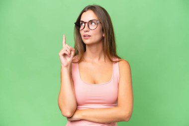 Genç ve güzel bir kadın izole edilmiş arka planda bir fikir düşünüyor.