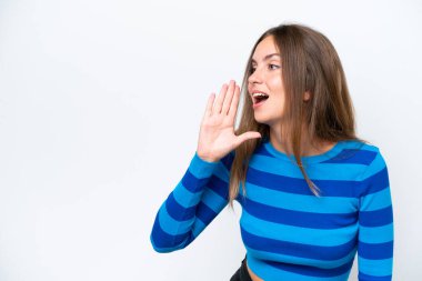 Beyaz arka planda izole edilmiş genç beyaz kadın ağzı sonuna kadar açık bağırıyor.