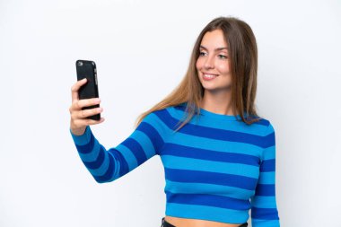 Beyaz arka planda izole edilmiş beyaz bir kadın selfie çekiyor.