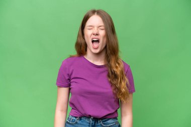 Tecrit edilmiş arka planda genç ve güzel bir kadın ağzı açık bağırıyor.