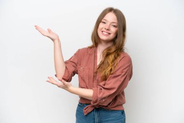 Beyaz arka planda izole edilmiş genç ve güzel bir kadın davet edilmek için ellerini yana uzatıyor.