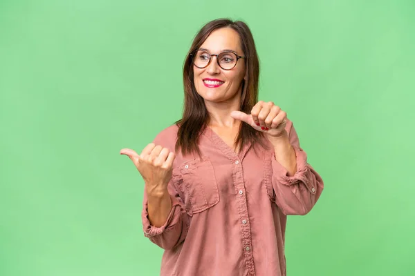 stock image Middle-aged caucasian woman over isolated background pointing to the side to present a product