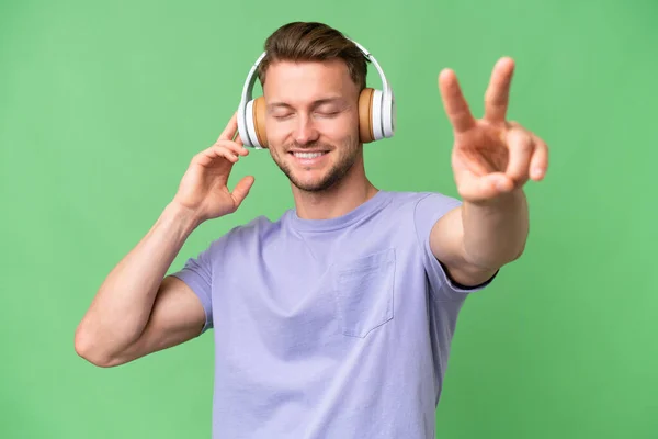Ung Blond Kaukasisk Man Över Isolerad Bakgrund Lyssna Musik Och — Stockfoto
