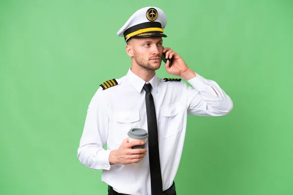 Pilot Samolotu Nad Odosobnionym Tle Trzymając Kawę Zabrania Telefon Komórkowy — Zdjęcie stockowe