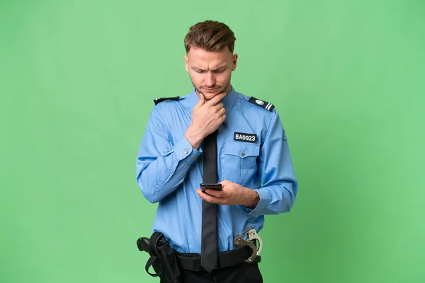 Jovem Policial Sobre Fundo Isolado Pensando Enviando Uma Mensagem — Fotografia de Stock