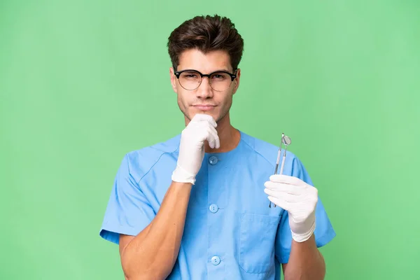 Jovem Dentista Homem Segurando Ferramentas Sobre Pensamento Fundo Isolado — Fotografia de Stock