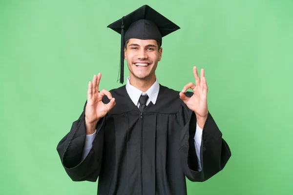 Молодой Выпускник Университета Кавказский Человек Изолированном Фоне Показывает Знак Пальцами — стоковое фото