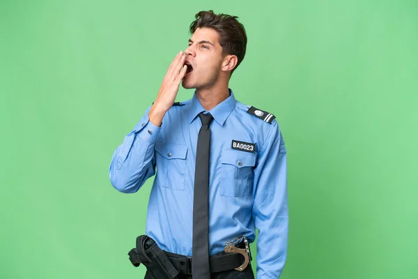 Junger Polizist Über Isoliertem Hintergrund Gähnt Und Deckt Weit Geöffneten — Stockfoto