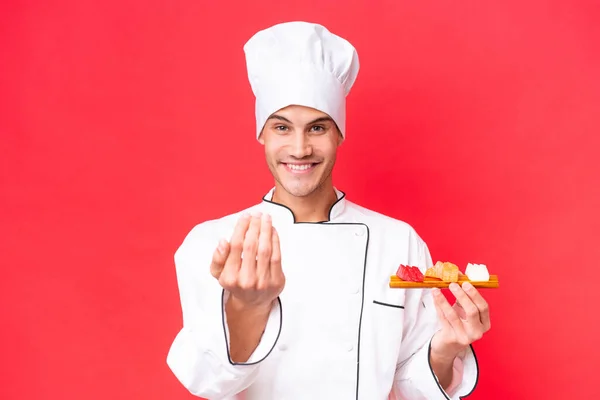 Jovem Cozinheiro Caucasiano Segurando Sashimi Isolado Fundo Vermelho Convidando Para — Fotografia de Stock