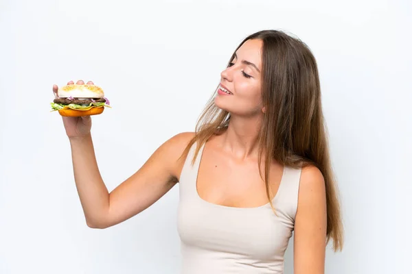 Młoda Ładna Kobieta Trzyma Hamburgera Białym Tle Szczęśliwym Wyrazem Twarzy — Zdjęcie stockowe