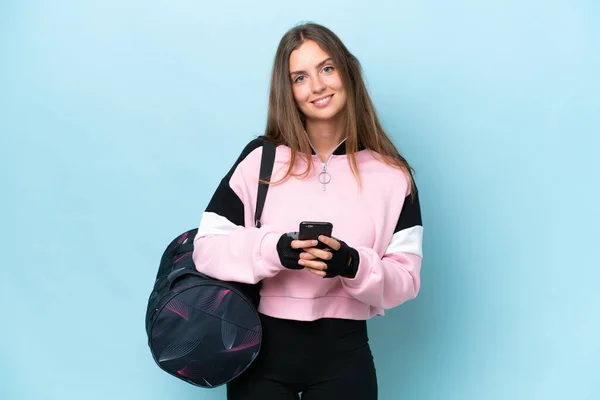 Young Sport Woman Sport Bag Isolated Blue Background Sending Message — стоковое фото