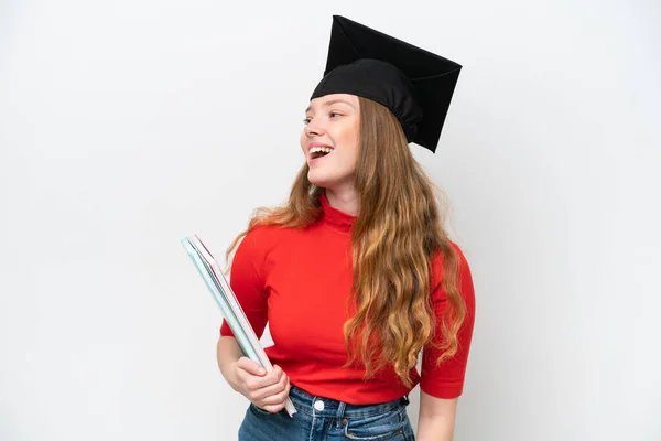 Junge Universitätsabsolventin Isoliert Auf Weißem Hintergrund Und Lacht Seitenlage — Stockfoto