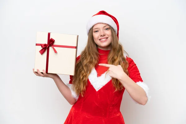若いです白人の背景に隔離された贈り物を保持し それを指すクリスマスドレスを持つ白人女性 — ストック写真