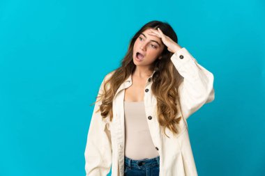 Mavi arka planda mahsur kalmış beyaz bir kadın. Sürpriz bir ifadeyle yan tarafa bakarken.