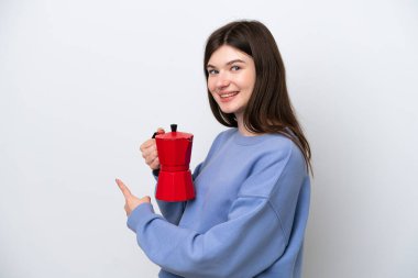 Beyaz arka planda izole edilmiş kahve demliği tutan genç bir Rus kadın.