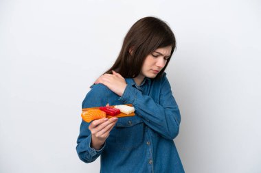 Beyaz arka planda saşimi tutan genç bir Rus kadın omuz ağrısından muzdarip.