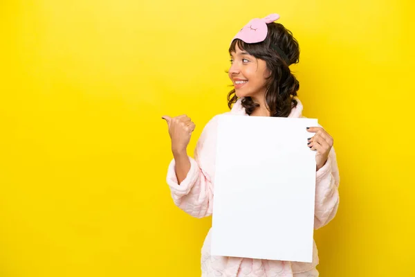 Νεαρή Λατίνα Γυναίκα Πιτζάμες Απομονωμένη Κίτρινο Φόντο Κρατώντας Ένα Άδειο — Φωτογραφία Αρχείου