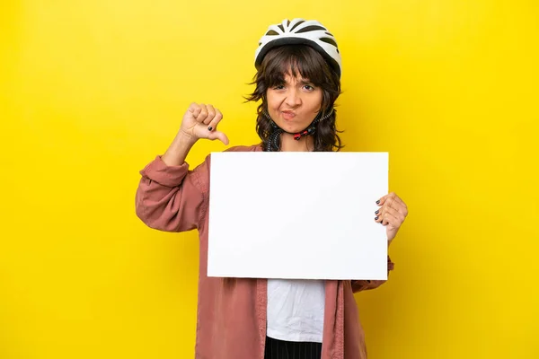 Jovem Ciclista Latino Mulher Isolada Fundo Amarelo Segurando Cartaz Vazio — Fotografia de Stock