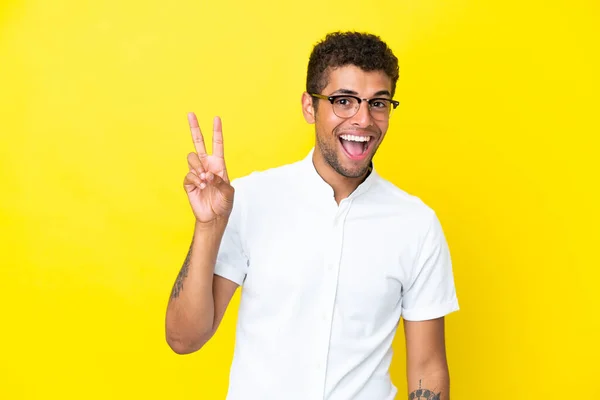 Sarı Arka Planda Izole Edilmiş Yakışıklı Brezilyalı Genç Adam Gülümsüyor — Stok fotoğraf