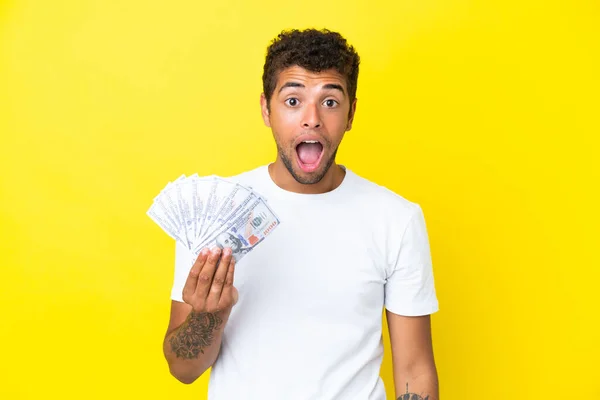 Νεαρός Βραζιλιάνος Παίρνει Πολλά Χρήματα Που Απομονώνονται Κίτρινο Φόντο Έκφραση — Φωτογραφία Αρχείου