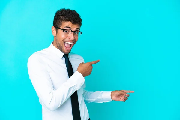 Jovem Empresário Brasileiro Isolado Fundo Azul Surpreendido Apontando Lado — Fotografia de Stock