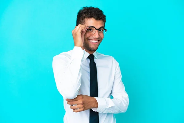若いビジネスブラジル人男性は眼鏡と幸せな青の背景に隔離された — ストック写真