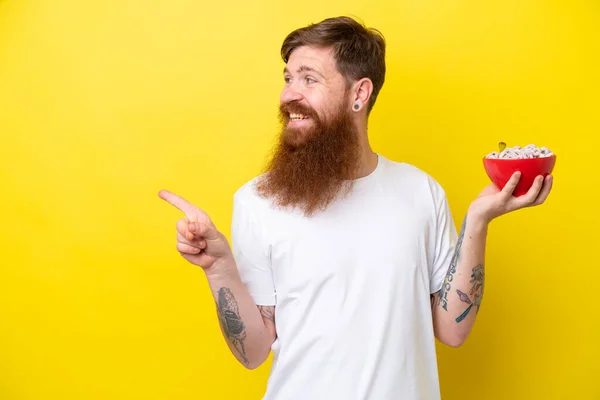 Roodharige Man Met Baard Eet Een Kom Graan Geïsoleerd Gele — Stockfoto