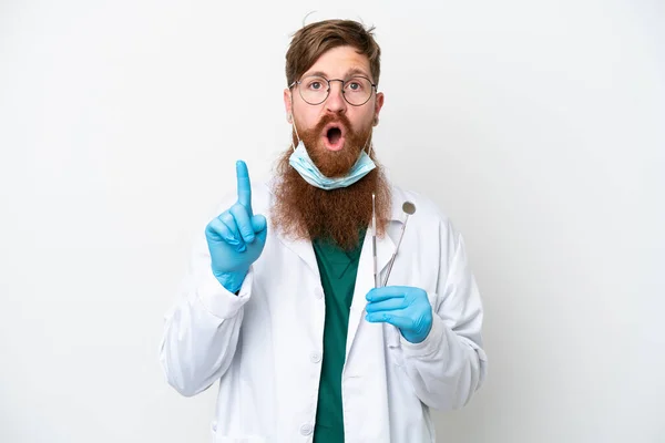 stock image Dentist reddish man holding tools isolated on white background intending to realizes the solution while lifting a finger up