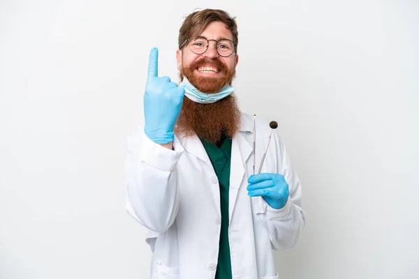 歯医者の赤みを帯びた男は白い背景に隔離されたツールを保持して来るジェスチャーを行う — ストック写真