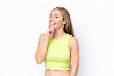 Beyaz arka planda izole edilmiş genç beyaz kadın yan bakıyor ve gülümsüyor.