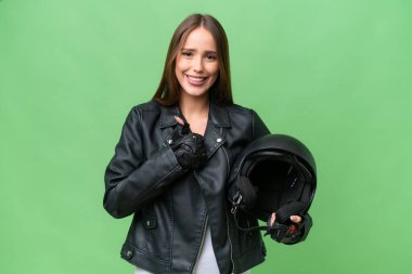 Motosiklet kaskı takan, izole edilmiş bir geçmişi olan güzel beyaz bir kadın baş parmak işareti yapıyor.