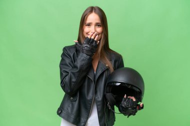 Motosiklet kaskı takmış, mutlu ve gülümseyen genç beyaz bir kadın.