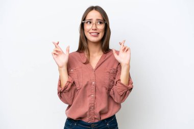 Beyaz arka planda izole edilmiş beyaz, güzel beyaz bir kadın parmaklarını çapraz yapıp en iyisini diliyor.