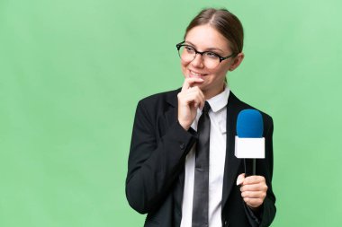 Genç TV sunucusu beyaz kadın izole edilmiş arka planda bir fikir üretiyor ve bakıyor.