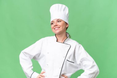 Genç aşçı kadın izole edilmiş yeşil arka plan 