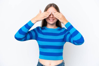 Beyaz arka planda izole edilmiş genç, güzel sarışın kadın. Gözleri elleriyle kaplıyor ve gülümsüyor.